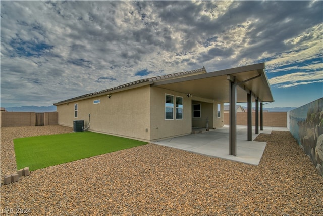 rear view of house with central AC and a patio area