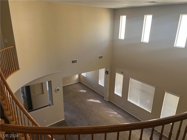 stairs with a towering ceiling and carpet floors