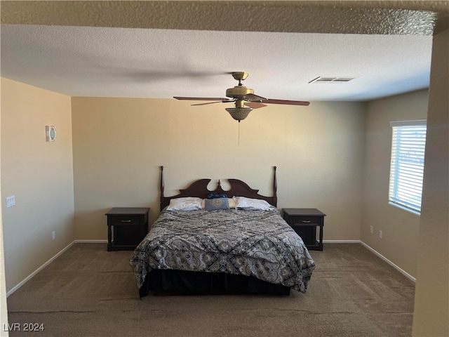 bedroom featuring ceiling fan, carpet floors, and a textured ceiling