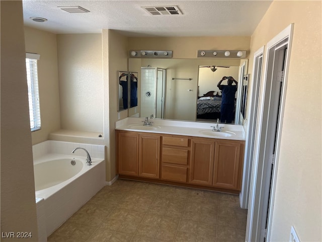 bathroom with a textured ceiling, a tub, and vanity