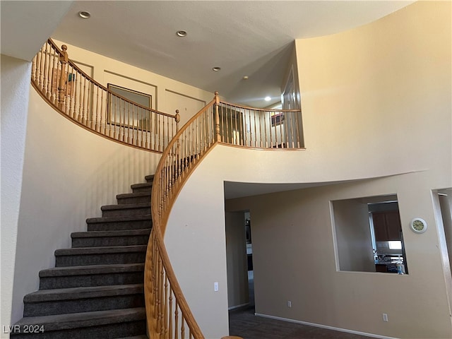 staircase featuring a towering ceiling