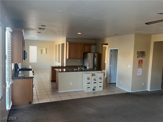 kitchen with ceiling fan, stainless steel fridge, stove, and light tile patterned floors