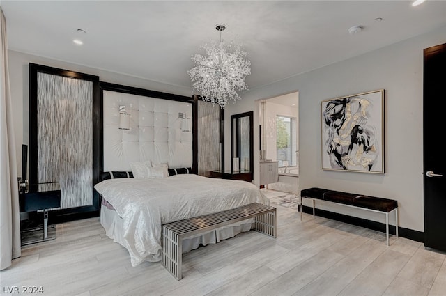 bedroom featuring a notable chandelier, hardwood / wood-style flooring, and ensuite bathroom