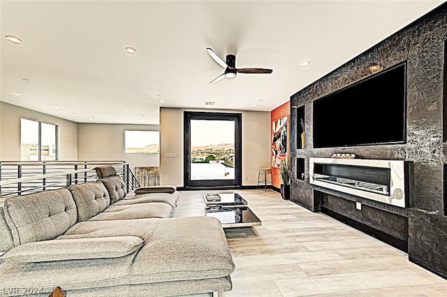 living room featuring light wood-type flooring and ceiling fan