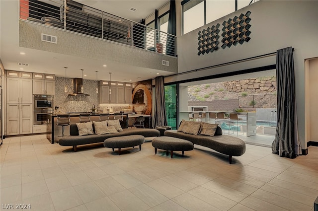 living room with light tile patterned flooring and a high ceiling