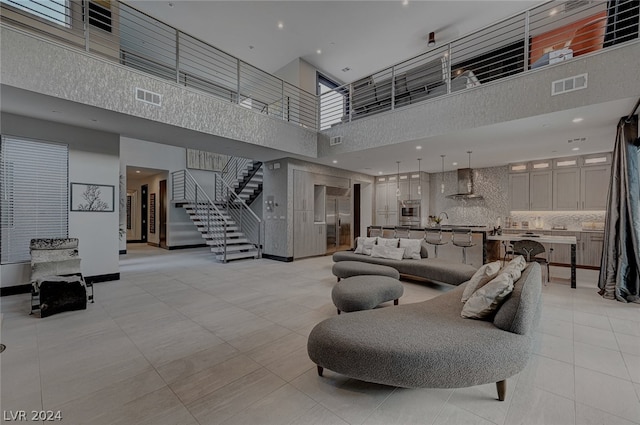 interior space featuring light tile patterned floors, sink, and a high ceiling