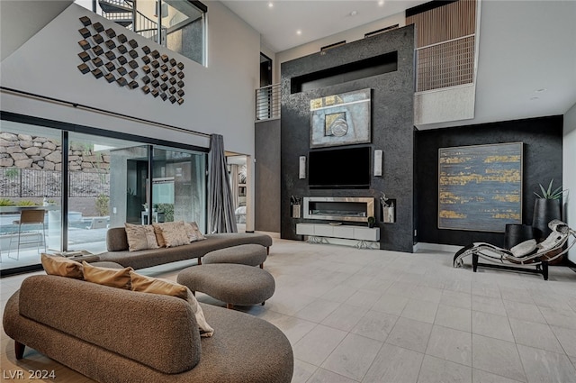 tiled living room featuring a towering ceiling and a fireplace