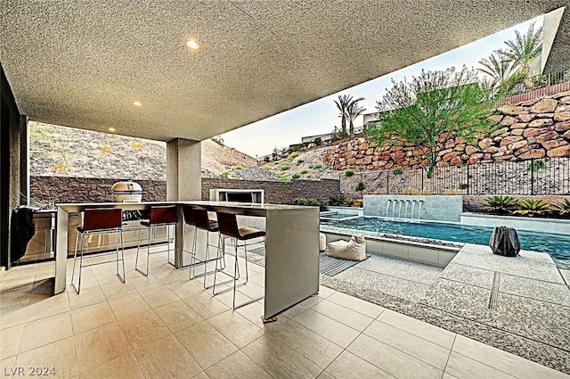 view of patio / terrace featuring a fenced in pool and an outdoor bar