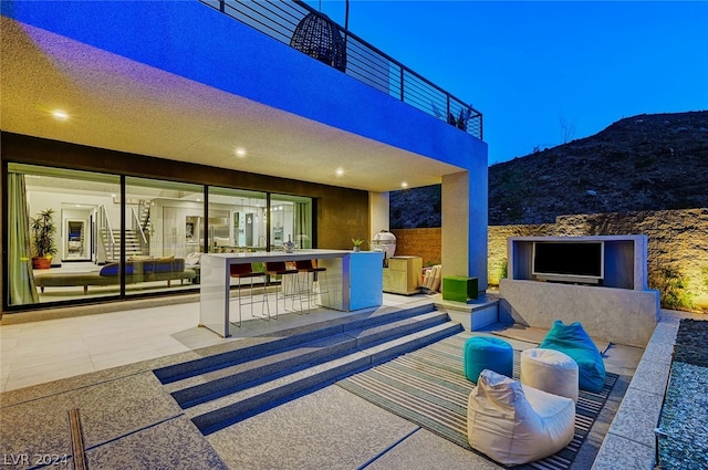 view of patio / terrace featuring exterior kitchen, a mountain view, exterior bar, and a balcony