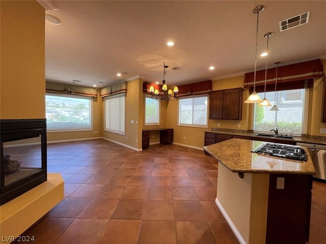 kitchen with plenty of natural light, pendant lighting, dark tile patterned flooring, and appliances with stainless steel finishes