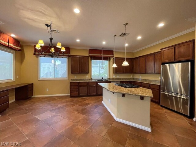 kitchen with a breakfast bar area, pendant lighting, light stone countertops, a center island, and high quality fridge