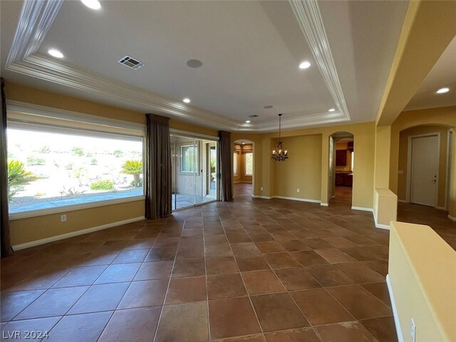 unfurnished living room featuring a tray ceiling and dark tile patterned floors