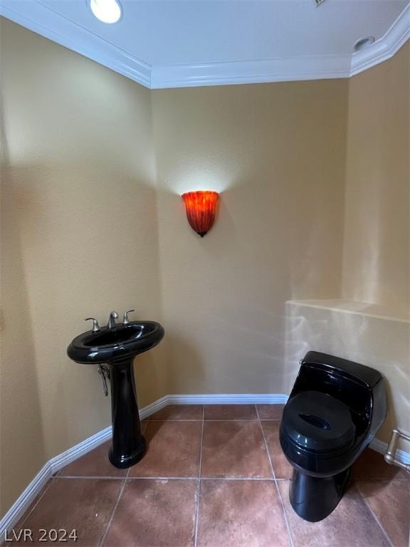 bathroom with ornamental molding, toilet, and tile patterned flooring