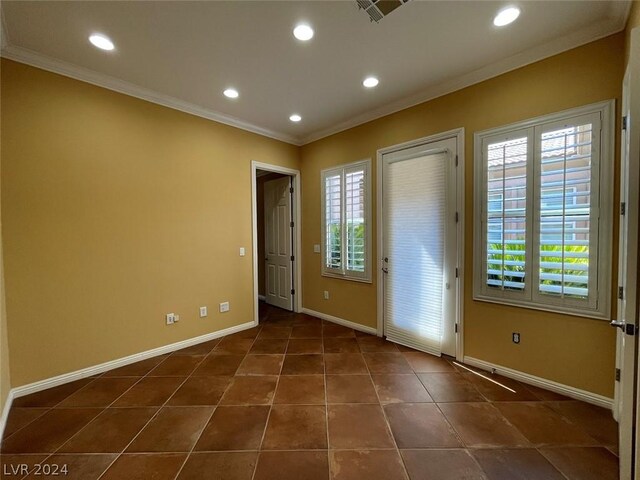 foyer featuring crown molding and dark tile patterned flooring