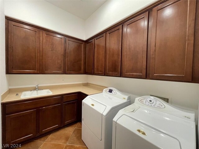 laundry area with sink, separate washer and dryer, cabinets, and light tile patterned floors