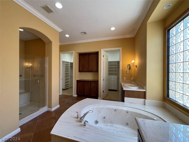 bathroom with a healthy amount of sunlight, tile patterned floors, plus walk in shower, and vanity