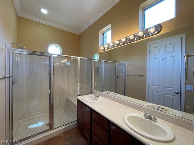 bathroom featuring a shower with shower door, tile patterned floors, crown molding, and dual bowl vanity