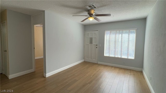 unfurnished room featuring a textured ceiling, ceiling fan, and light hardwood / wood-style flooring