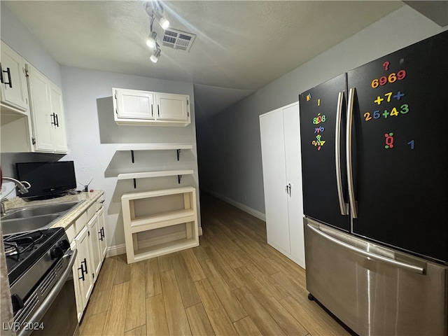 kitchen featuring white cabinetry, light hardwood / wood-style floors, sink, track lighting, and appliances with stainless steel finishes