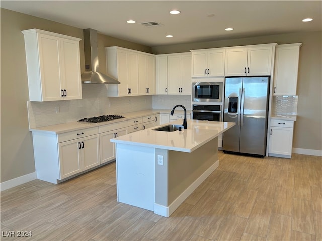 kitchen featuring white cabinets, appliances with stainless steel finishes, and wall chimney range hood