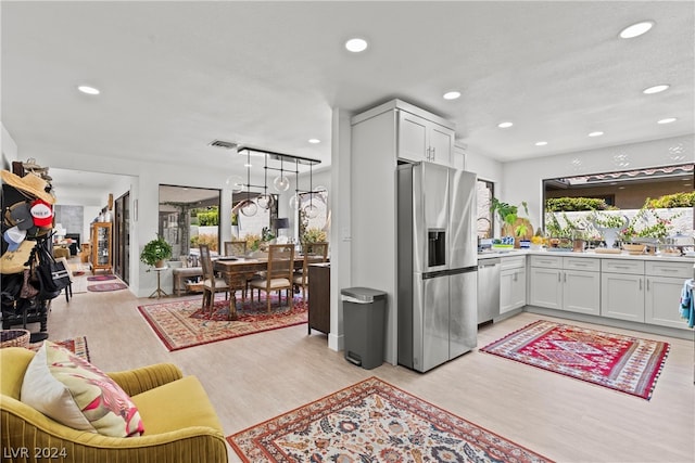 kitchen featuring white cabinetry, a wealth of natural light, and stainless steel appliances