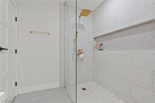 bathroom with tile patterned flooring and a tile shower