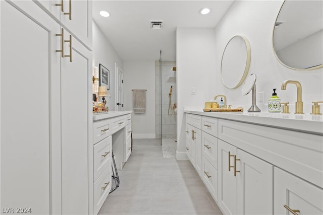 bathroom with vanity and a tile shower