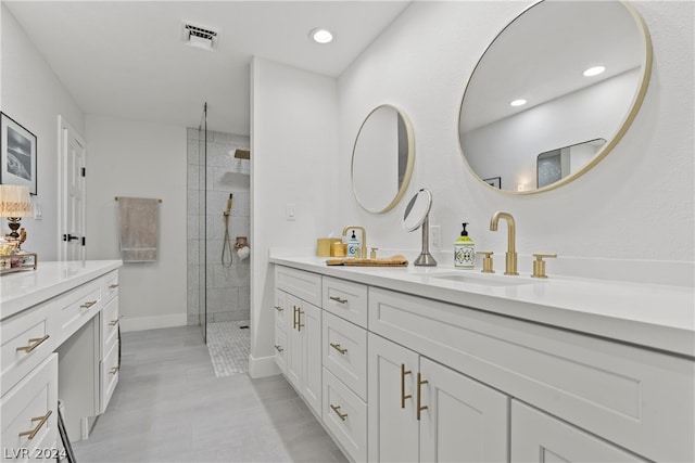 bathroom featuring tiled shower and vanity