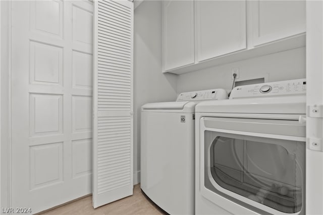 washroom featuring light hardwood / wood-style flooring, cabinets, and independent washer and dryer