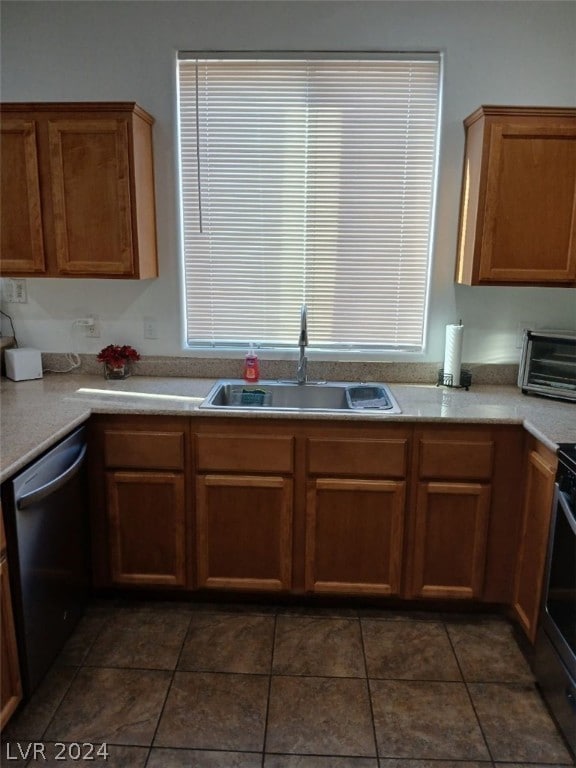 kitchen with sink, dishwasher, range with electric cooktop, and dark tile patterned floors