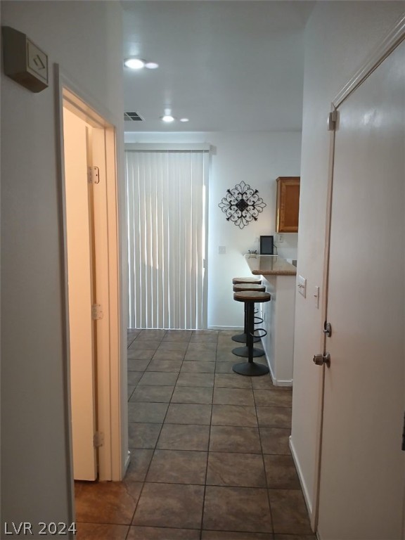 corridor with tile patterned flooring, visible vents, and recessed lighting