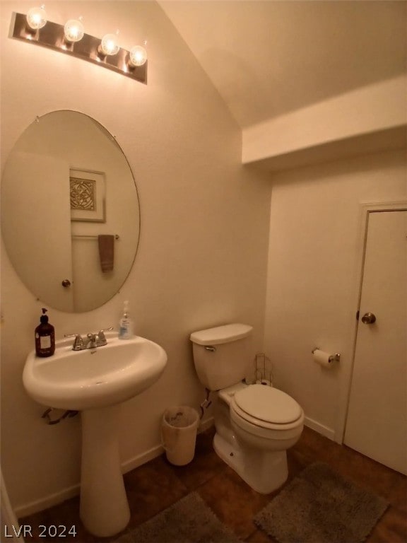 half bath featuring toilet and baseboards