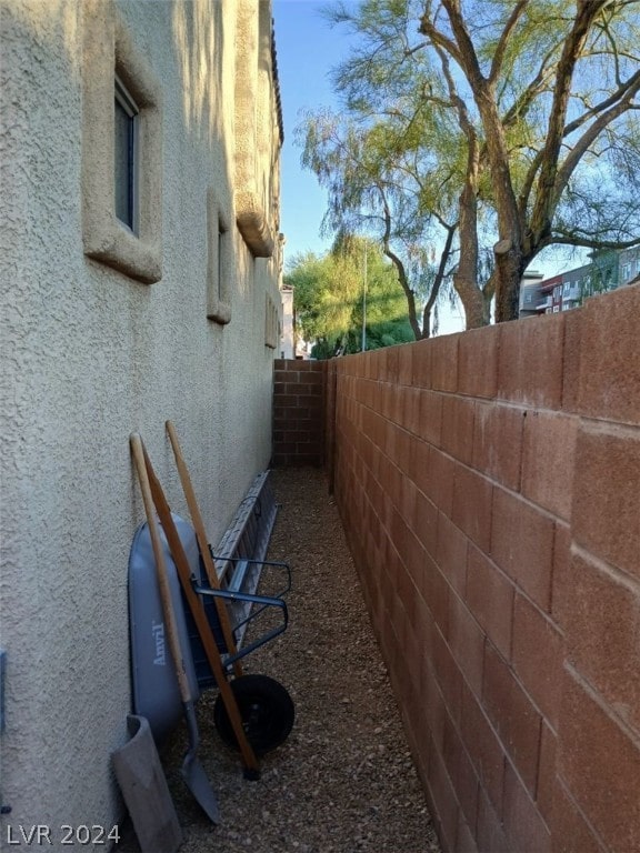 view of side of property with a fenced backyard and stucco siding