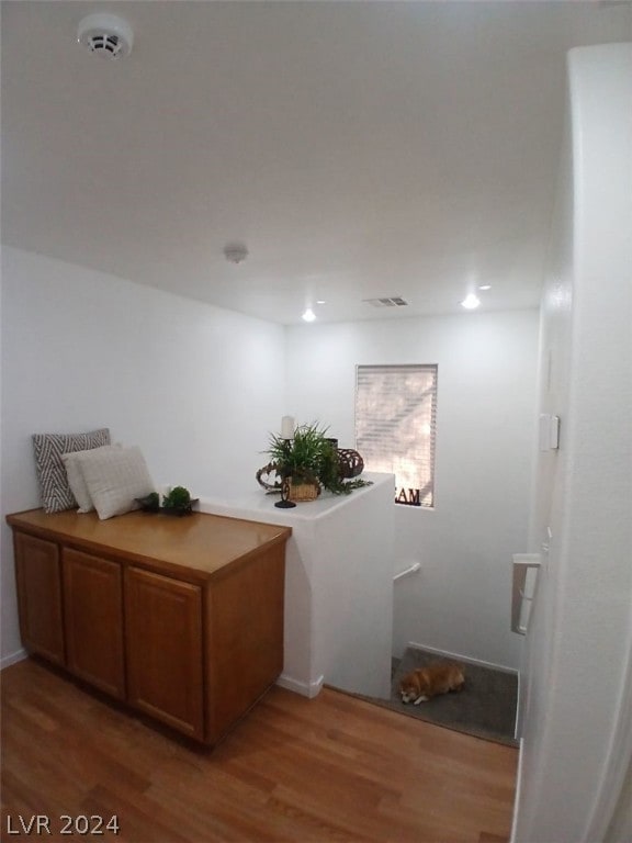 corridor featuring visible vents and wood finished floors