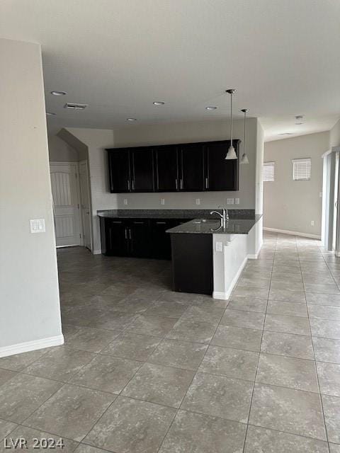 kitchen featuring decorative light fixtures, kitchen peninsula, and sink