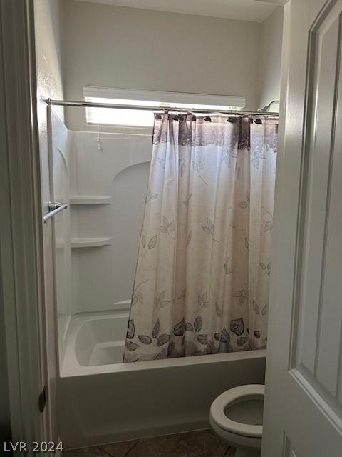 bathroom with shower / tub combo with curtain and toilet