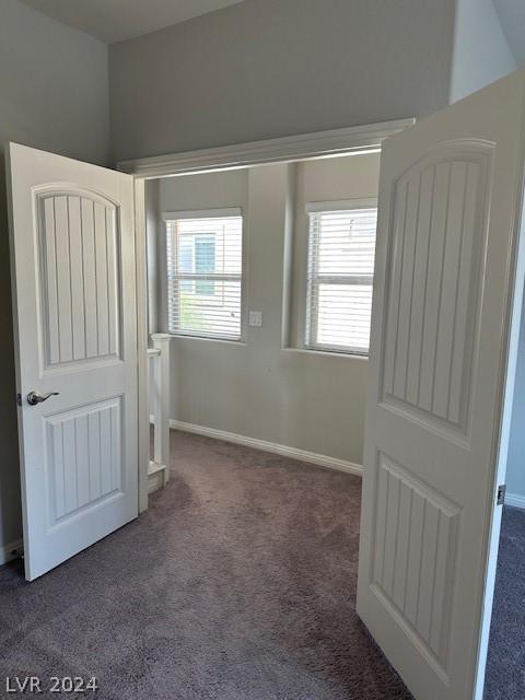 unfurnished bedroom with dark colored carpet