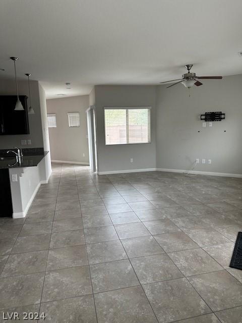 unfurnished living room with light tile patterned floors and ceiling fan