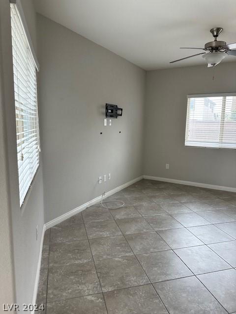 empty room with ceiling fan and light tile patterned flooring