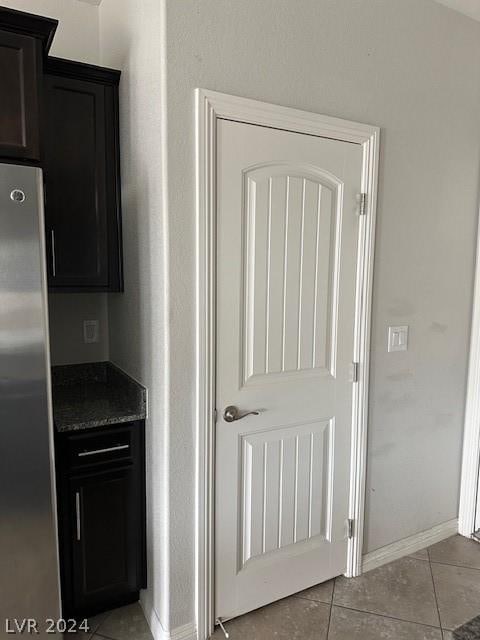 interior space featuring light tile patterned floors and stainless steel fridge