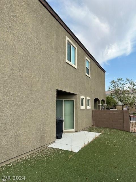 rear view of house featuring a yard and a patio area