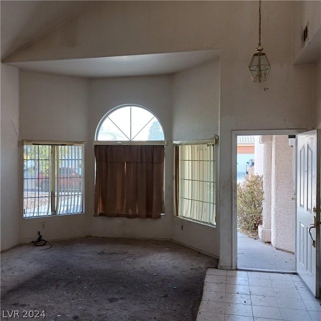 tiled entrance foyer featuring high vaulted ceiling