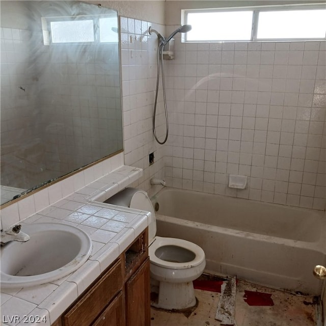 full bathroom with toilet, vanity, and tiled shower / bath