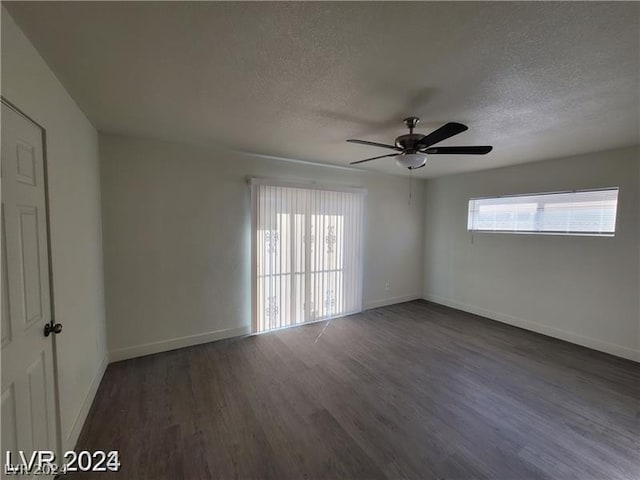 empty room with ceiling fan, dark hardwood / wood-style flooring, and a textured ceiling