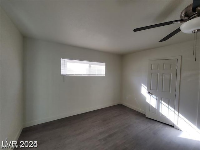 unfurnished room with ceiling fan and dark wood-type flooring