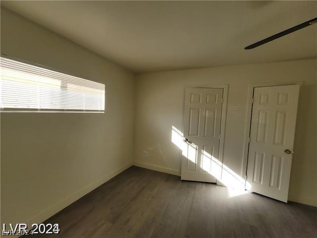 spare room with dark wood-type flooring and ceiling fan