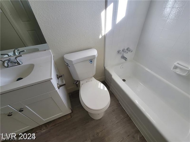 full bathroom featuring washtub / shower combination, hardwood / wood-style flooring, toilet, and vanity