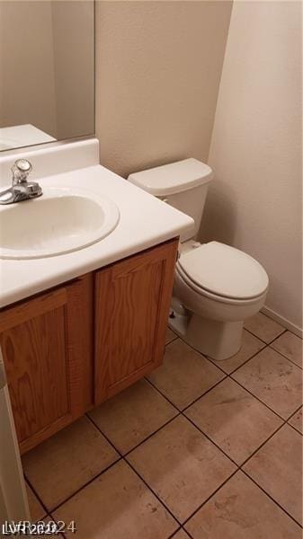 bathroom with toilet, tile patterned floors, and vanity