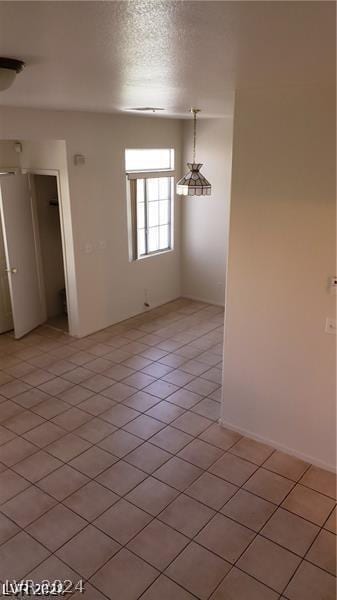 tiled spare room featuring a textured ceiling