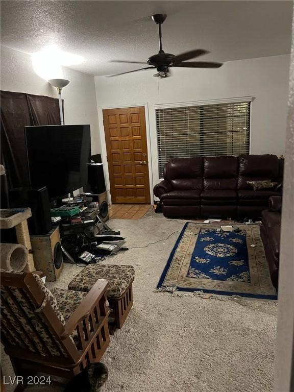 living room featuring carpet flooring, a textured ceiling, and ceiling fan